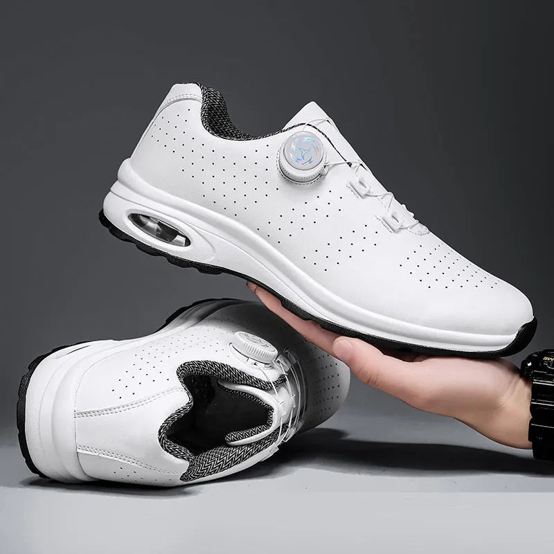 Black and white low-top tennis shoes with mesh upper and cross-shoulder straps on a composite sole.