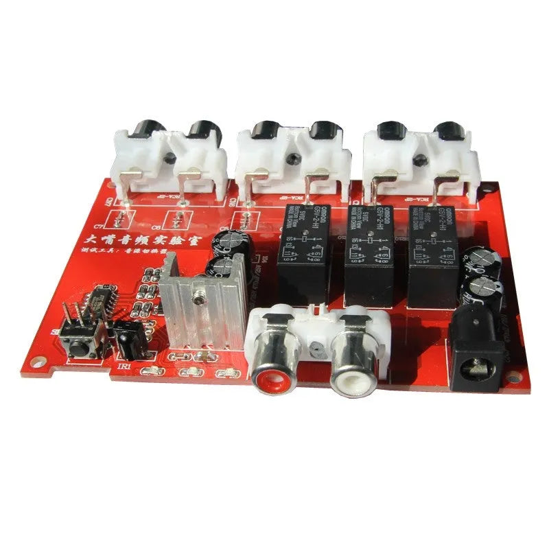 Silver aluminium audio source selector switch unit with front panel button and infrared remote.