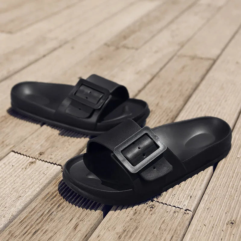 A pair of women's grey blue buckle slipper sandals with an adjustable strap on a soft EVA sole.