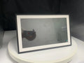 White 15.6 inch smart digital photo frame with wall bracket on a wooden table.