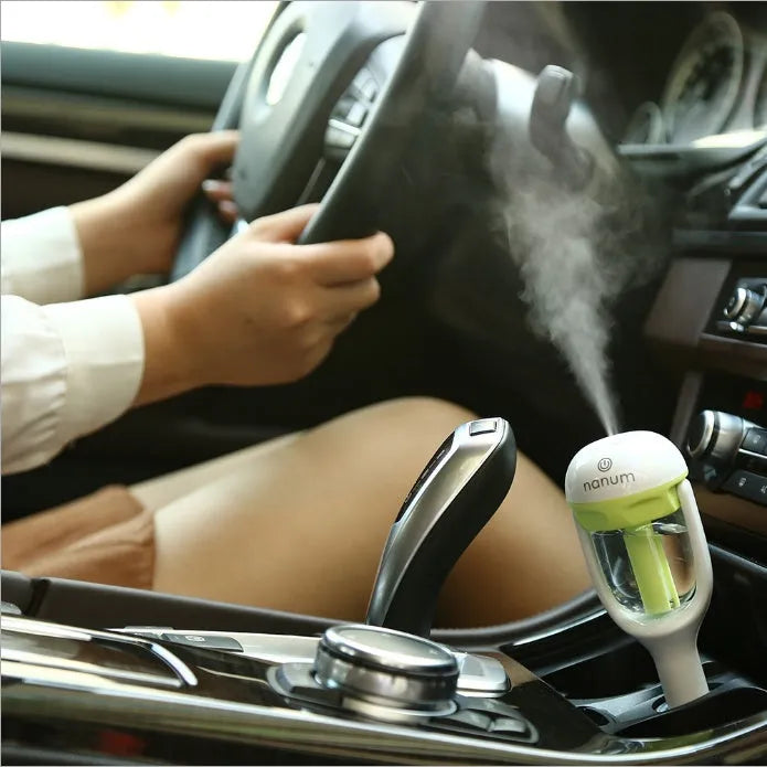 Compact portable car humidifier and essential oil diffuser unit in blue, green, pink, or purple.