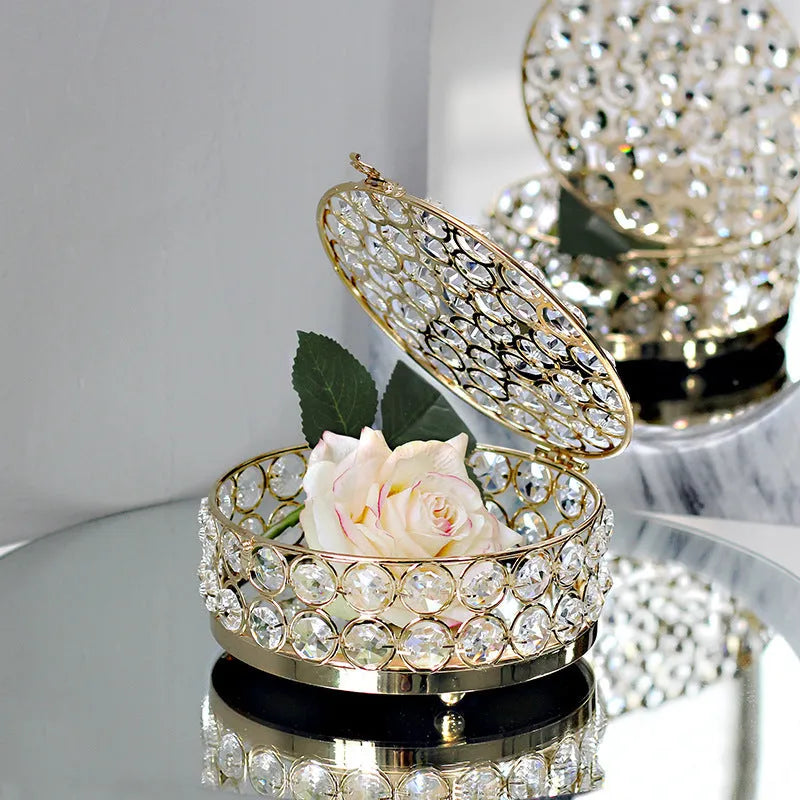 Transparent crystal glass jewelry storage box with a French gold-coloured metal frame on a table.