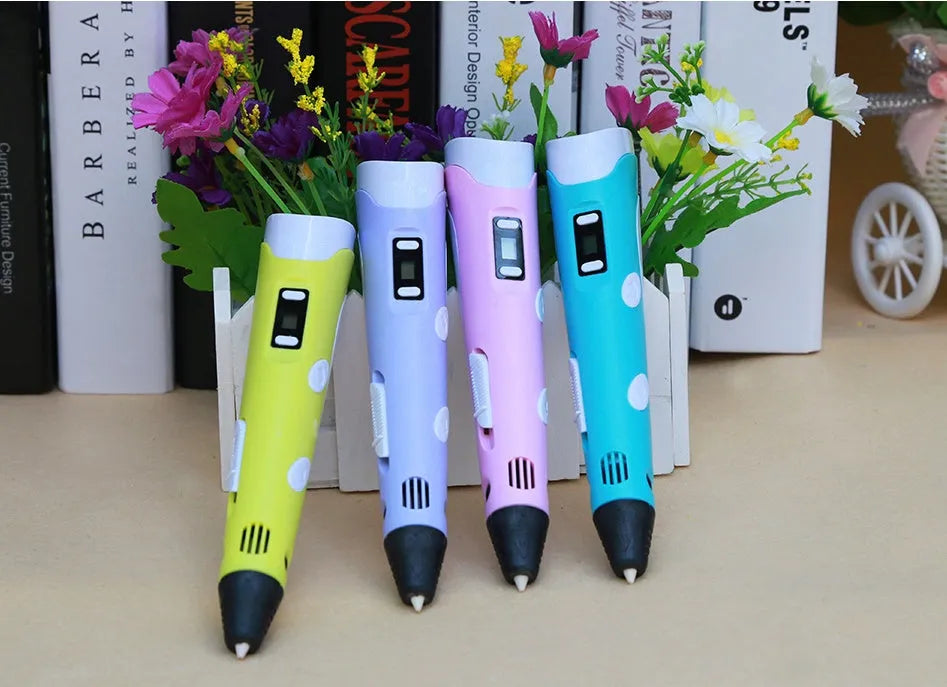 Yellow 3D printing pen with 12 colour PLA filament spools and UK power adapter on a white background