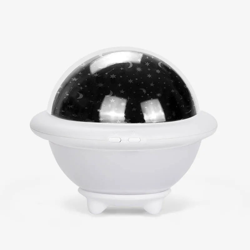 Green UFO-shaped plastic night light projecting a starry sky pattern on a wall.