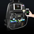 Car backrest storage bag in black leather with USB port and charging head, attached to a car seat