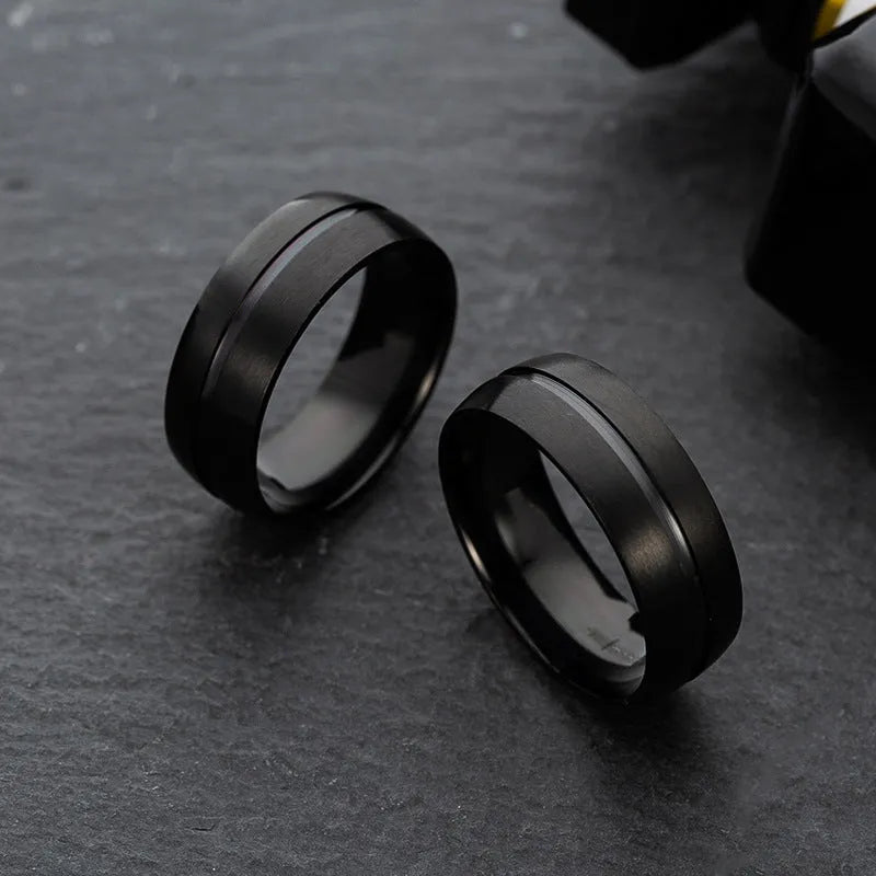 Black titanium steel ring with geometric design and alloy inlaid artificial stone on a dark background.