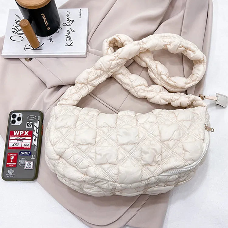 Women's light beige nylon cloud underarm messenger bag with a long adjustable shoulder strap.