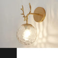 Minimalist round glass wall sconce with textured shade and black frame mounted on a white wall.