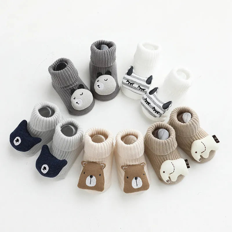 Pair of light grey baby socks with white non-slip silicone grip dots on the soles.