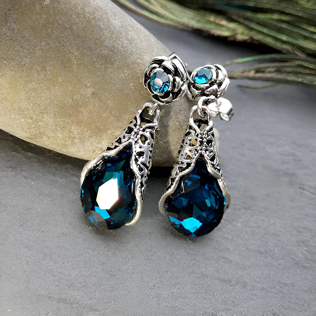 Retro peacock blue crystal water drop drop earrings on a light background