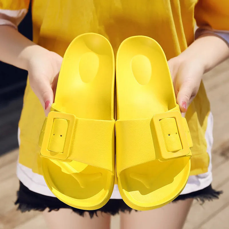 A pair of women's grey blue buckle slipper sandals with an adjustable strap on a soft EVA sole.