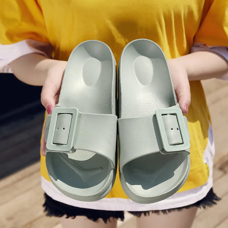 A pair of women's grey blue buckle slipper sandals with an adjustable strap on a soft EVA sole.