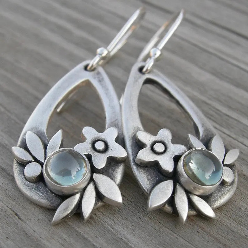 Silver ethnic style minimalist drop flower leaf alloy earrings with teardrop shape on neutral background