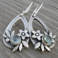 Silver ethnic style minimalist drop flower leaf alloy earrings with teardrop shape on neutral background