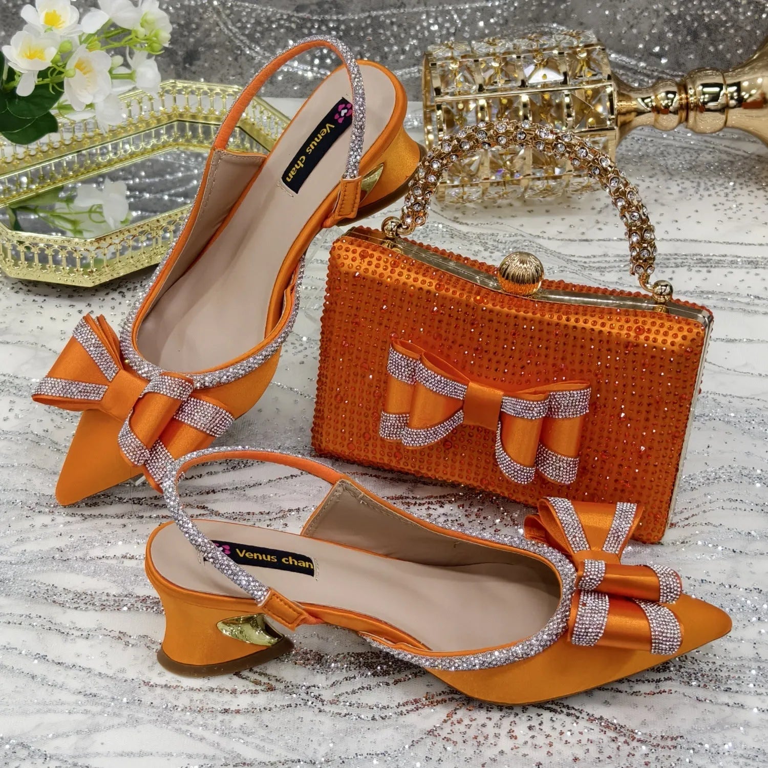 Women's pointed toe mid-heel sandals with square buckle and matching rhinestone bag in multiple colours.