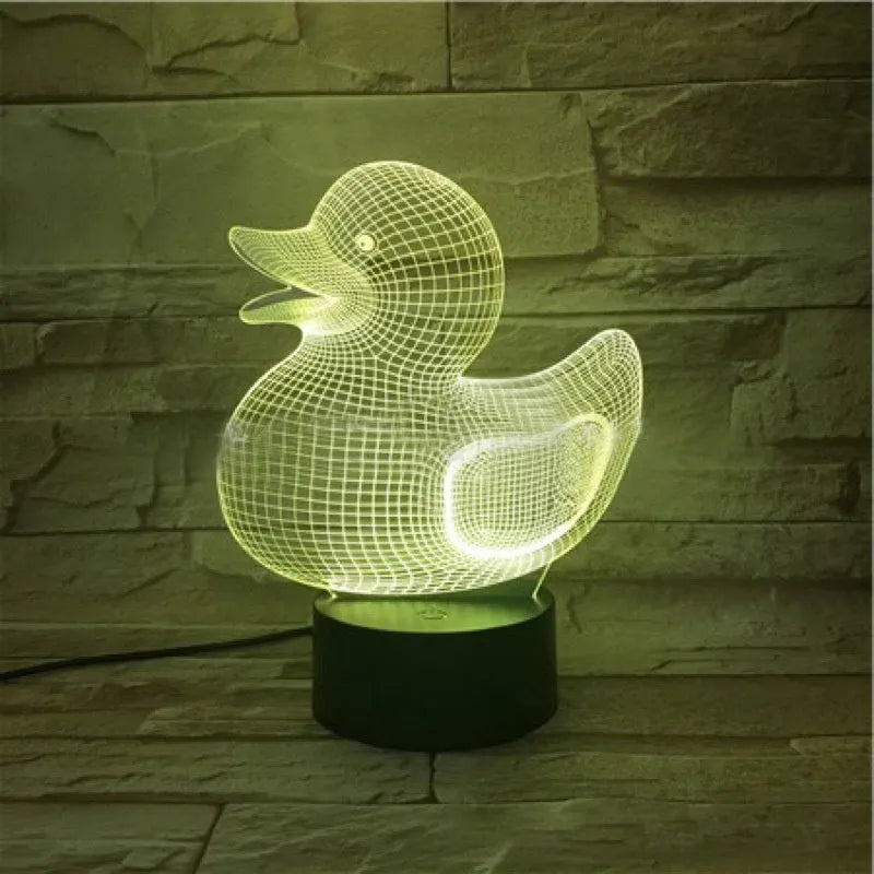 Yellow 3D duck-shaped LED night light with remote control on a table, showing soft multi-coloured glow.