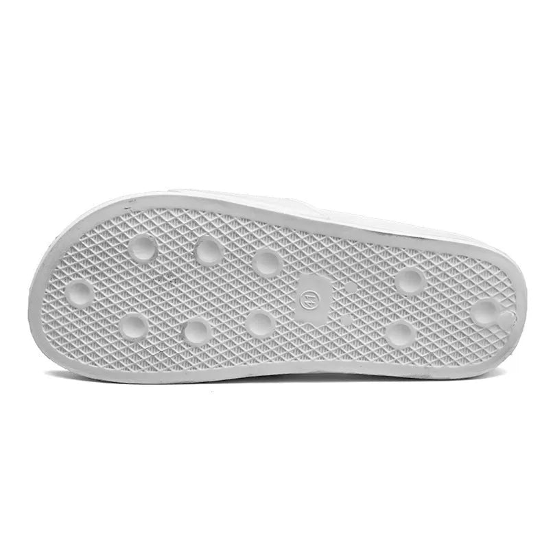 A pair of black open-toe men's slippers with a visible rubber sole, shown on a wooden floor.