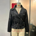 Black leather-style punk jacket with a Peter Pan collar and a drawstring waist, laid flat.