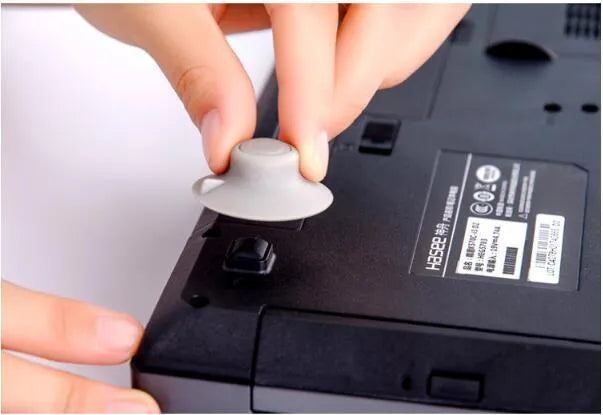 Grey plastic laptop cooling pad set showing two large and two small pads on a wooden desk.