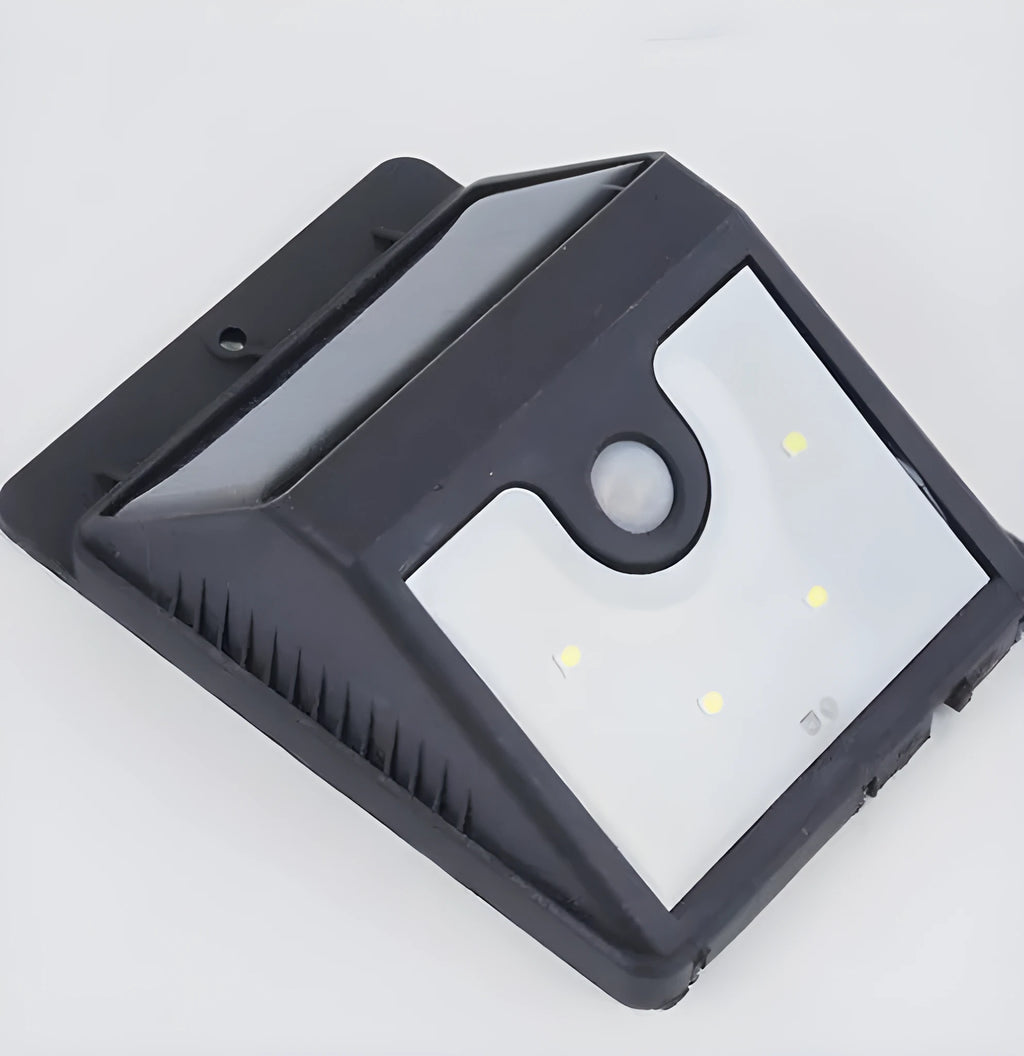 Four white rectangular solar-powered LED security lights with motion sensors mounted on an outdoor wall.