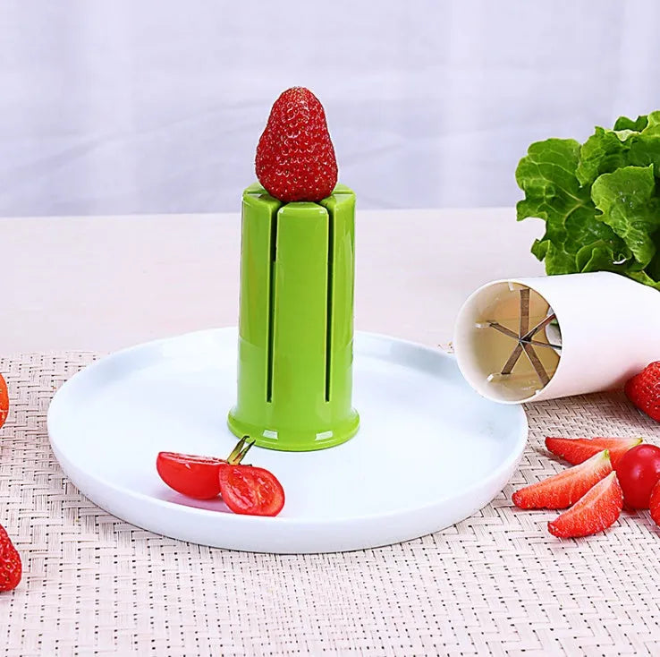 White handheld vegetable cutter with multiple stainless steel blades for slicing cucumbers, carrots, and strawberries.