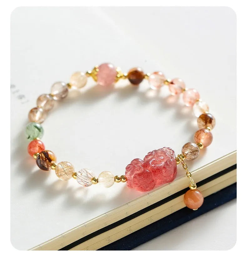 Natural strawberry quartz and copper bracelet with pearl accents on a wrist.