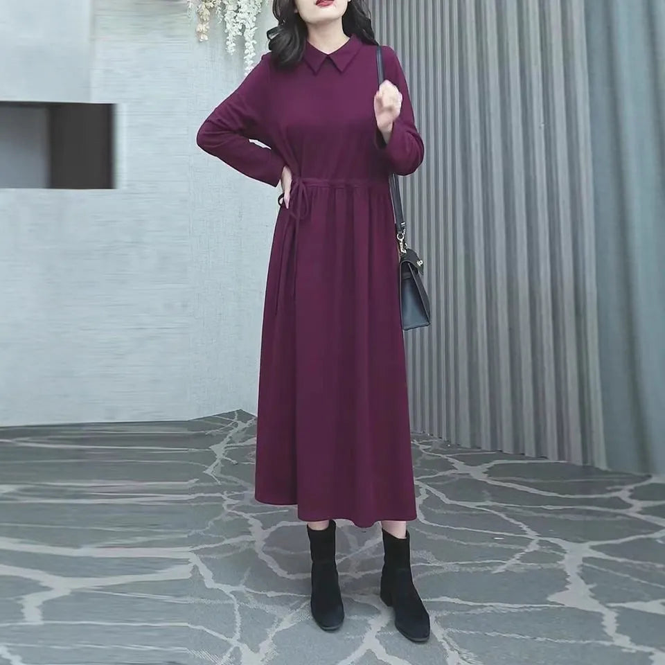 A purplish-red plus size winter dress with long sleeves and a long, flowing skirt, laid flat.