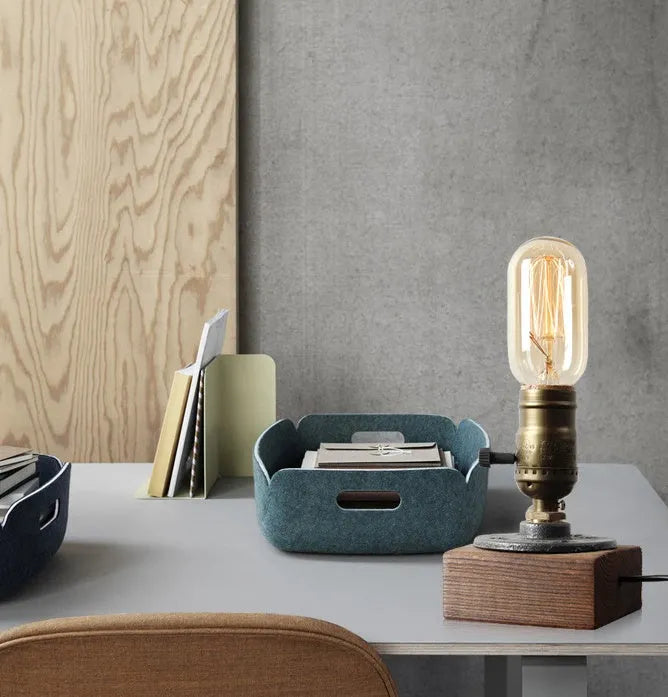 Small wooden and iron water pipe style table lamp on a surface.