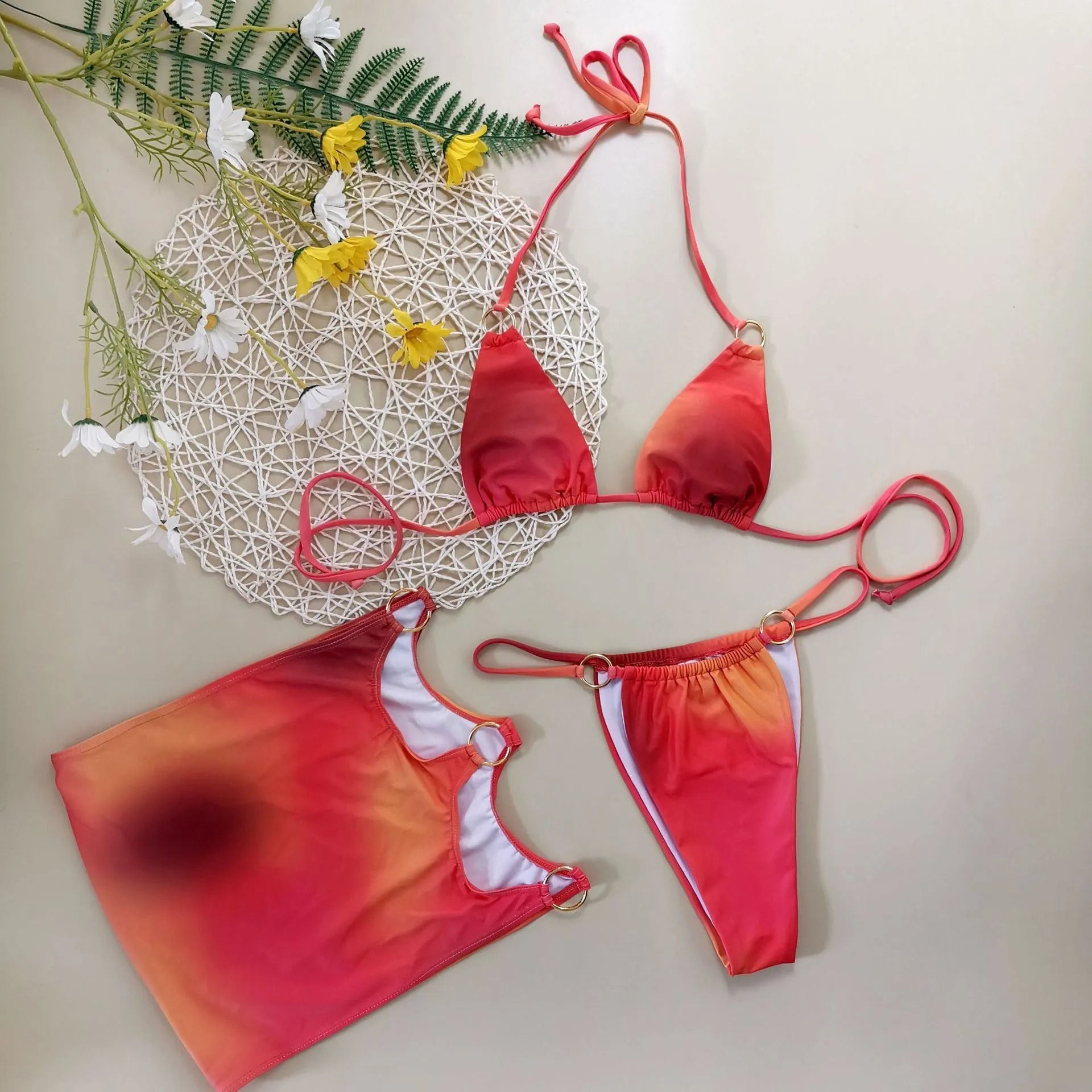 Women's gradient tie-dye halter neck bikini set with matching skirt on a beach background