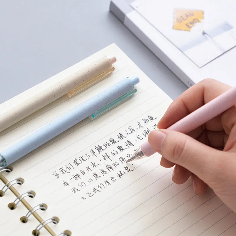 Set of twelve 0.5mm push-type gel pens in beige, blue, green, and pink barrels with black ink.