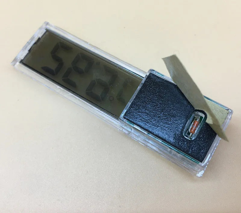 Gold digital stick-on aquarium thermometer on glass tank showing temperature reading