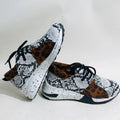 Women's suede sneakers with a wedge heel in leopard print, shown on a foot.