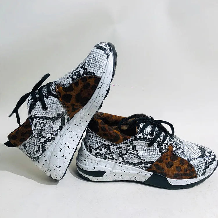 Women's suede sneakers with a wedge heel in leopard print, shown on a foot.
