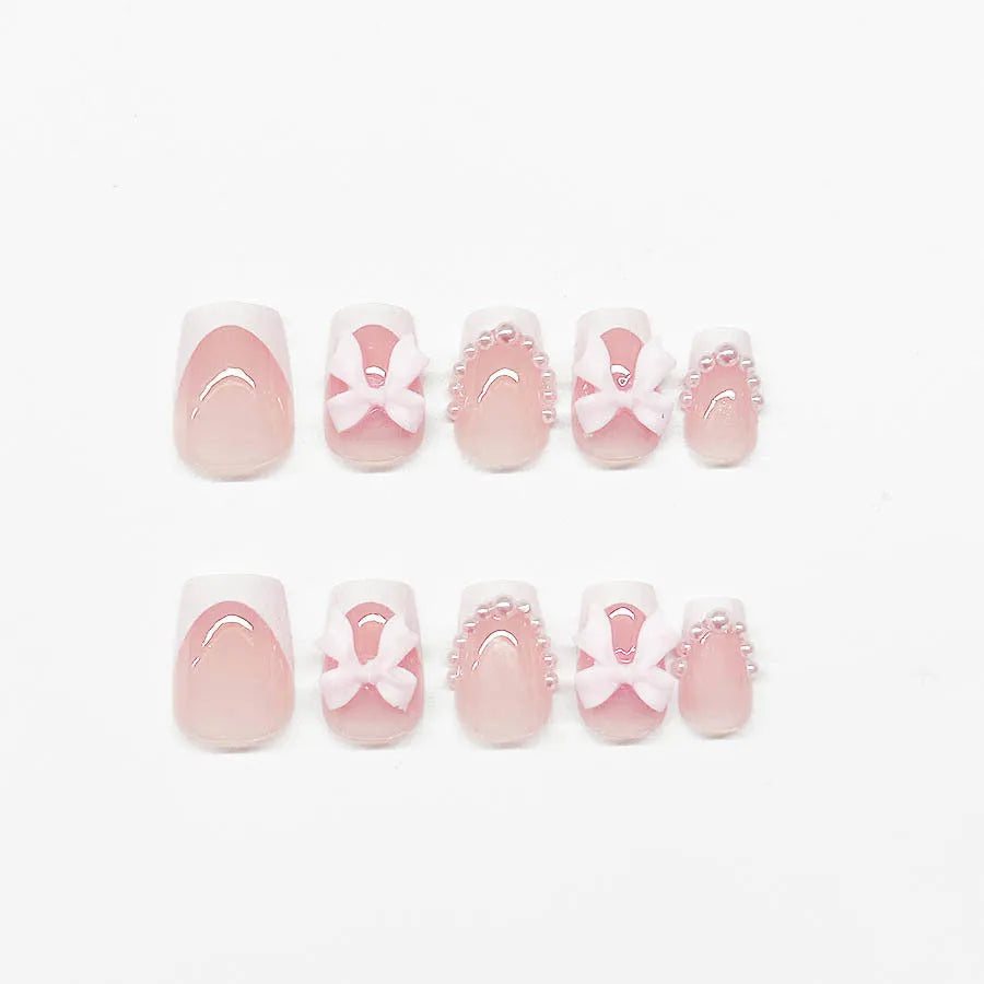 Set of 24 short, square, white-tipped French manicure false nails and a tube of nail glue on a pink background.