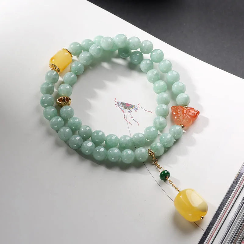 Close-up of a double-layer women's bracelet with green jade round beads and honey-coloured beeswax barrel beads.