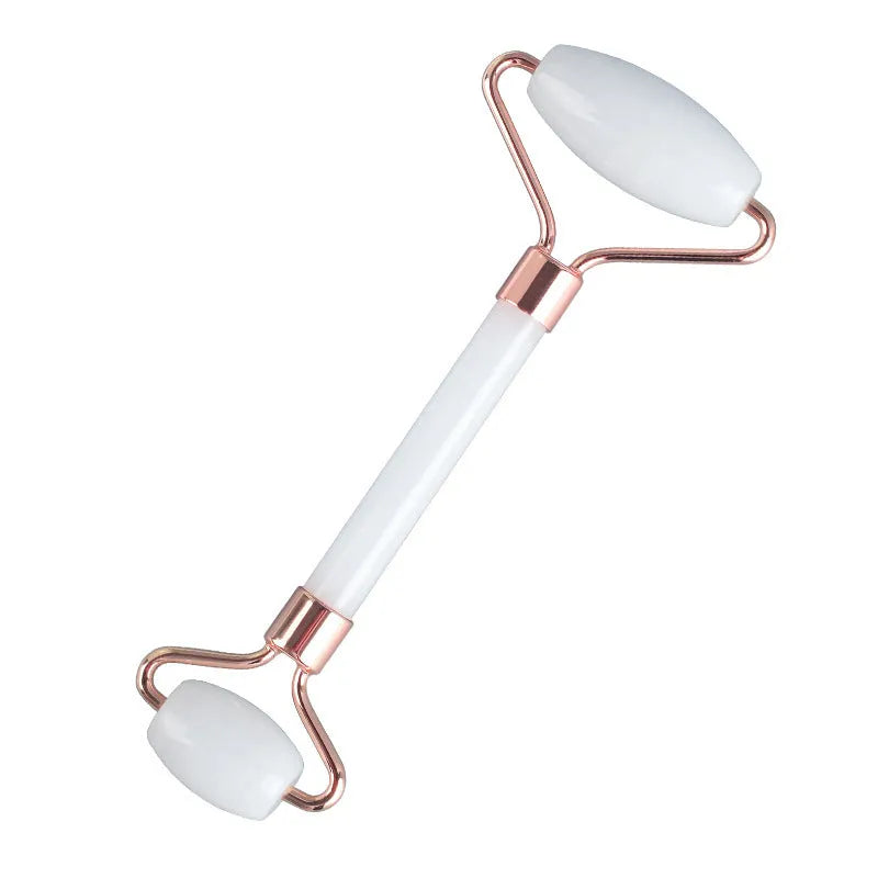 White jade double-headed facial roller and gua sha board set on a plain background.