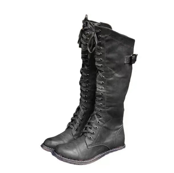 Black chunky heel high leg boot on a white background, showing round toe and low heel.