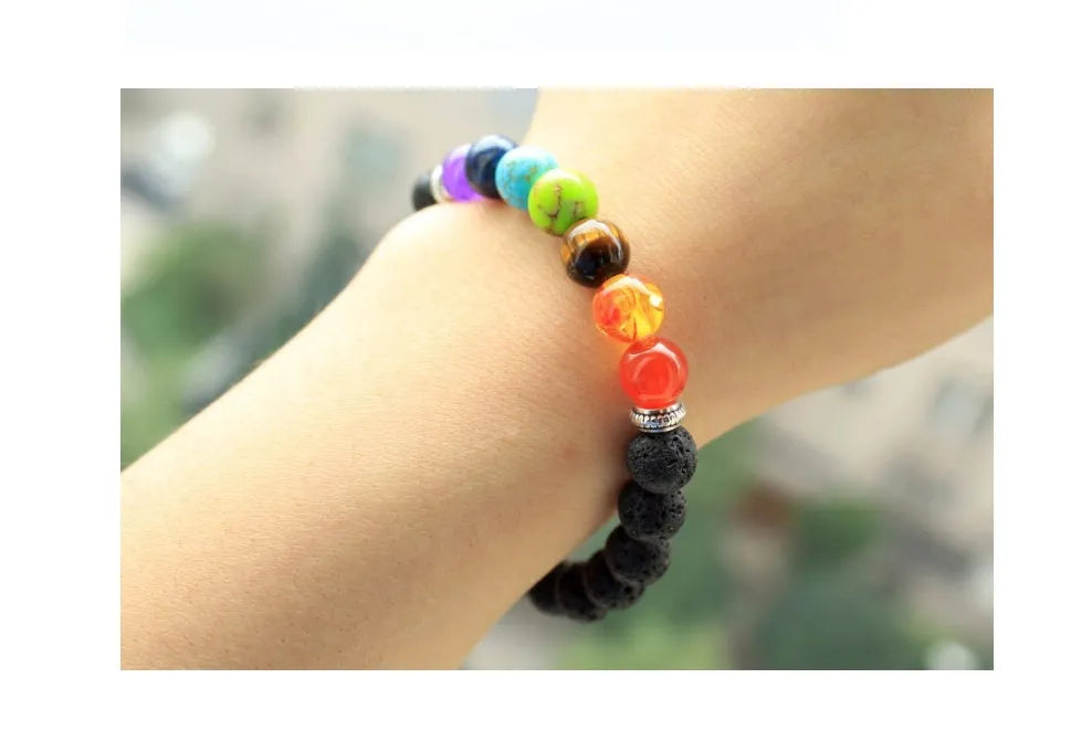 Handmade black lava seven chakra beaded bracelet on neutral background, 8mm or 10mm beads