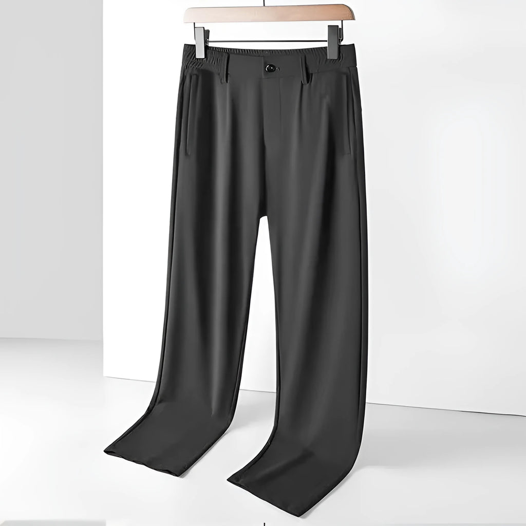 Man wearing loose-fit black ice silk straight-leg trousers with an elastic waistband.