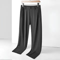 Man wearing loose-fit black ice silk straight-leg trousers with an elastic waistband.