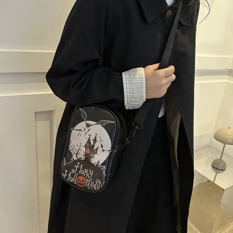 Black mini square crossbody bag with orange cartoon pumpkin, white ghost, and black bat graffiti print.