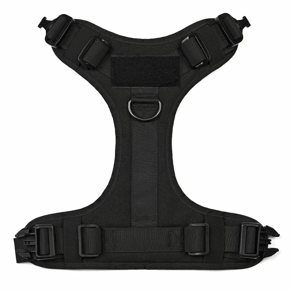 Military tactical dog harness in khaki with adjustable straps, pockets, and metal connection points on a German Shepherd