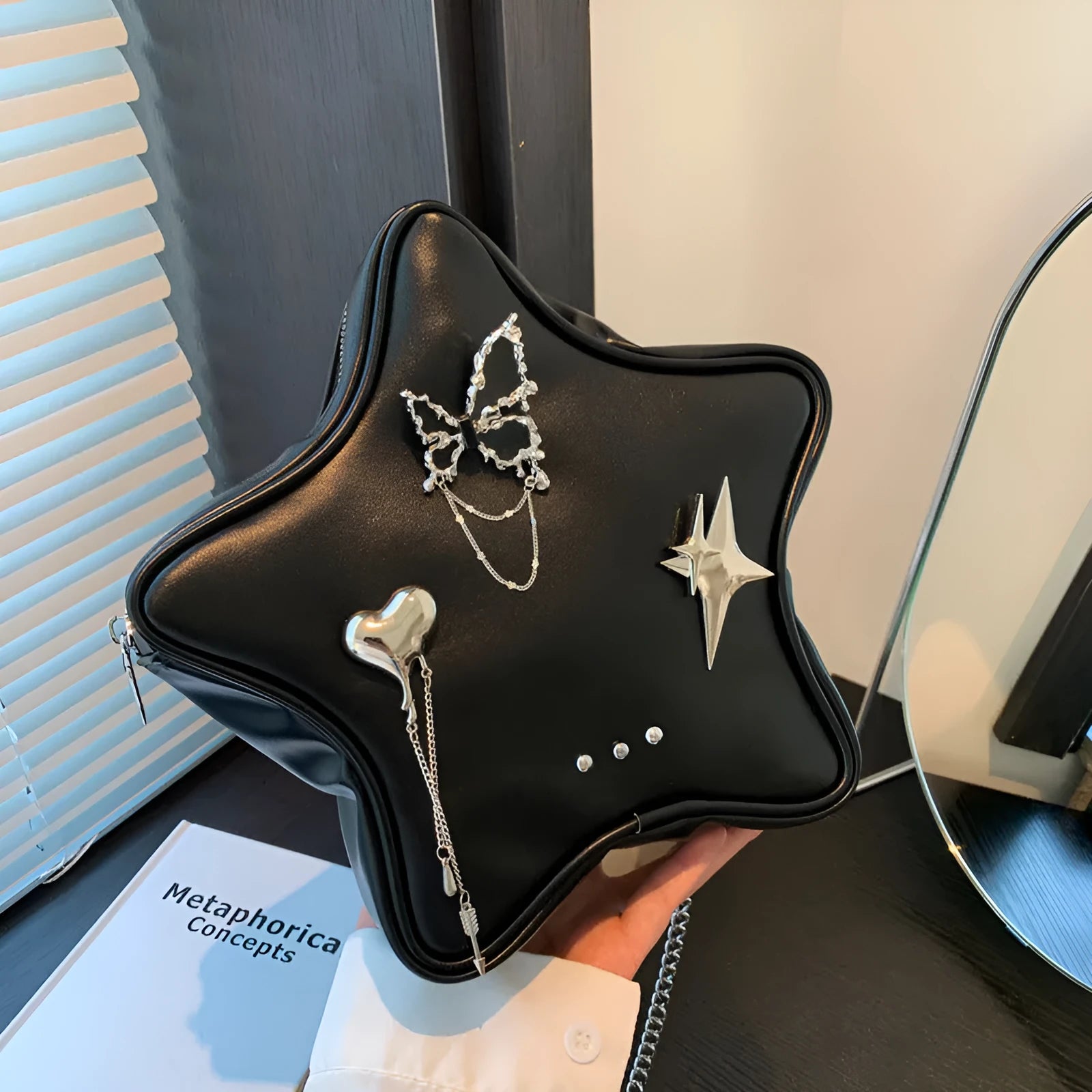 Black women's PU leather backpack with a silver metal butterfly star pendant, chain details, and an external pocket.