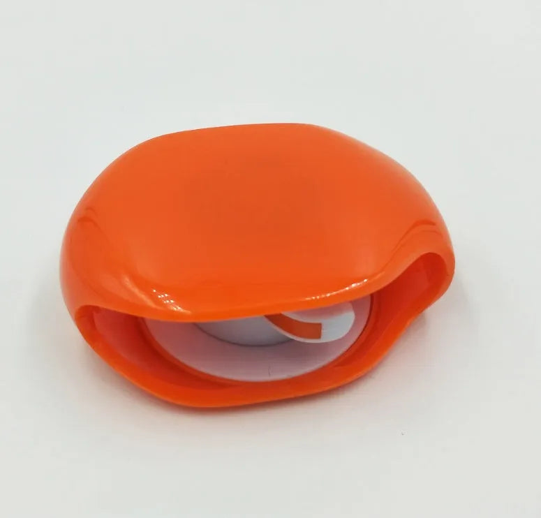 Compact automatic earphone winder in multiple colours on a grey background, showing extended cable.