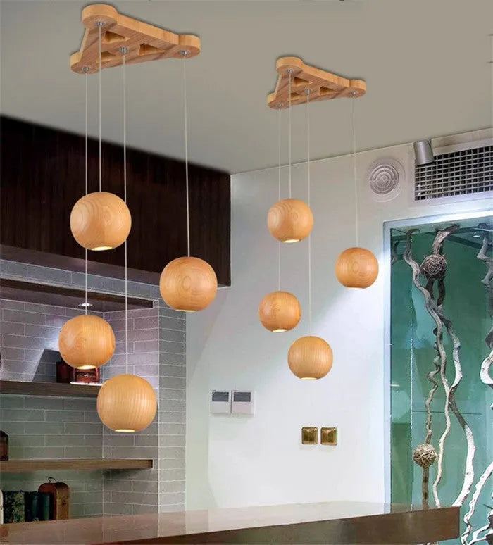 Nordic style solid wood ball chandelier hanging from ceiling with adjustable cord.