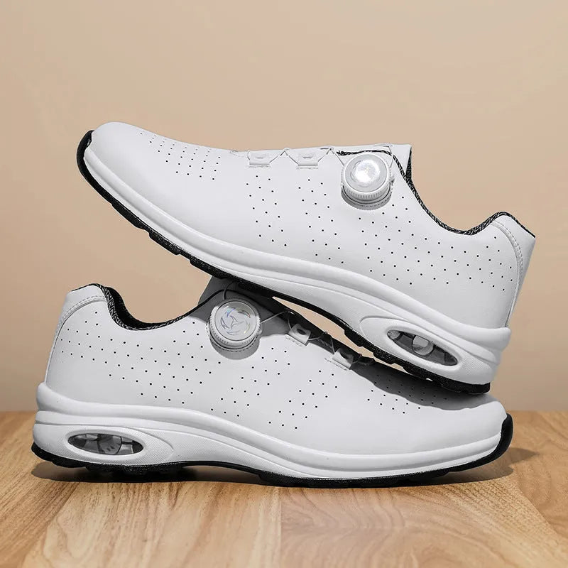 Black and white low-top tennis shoes with mesh upper and cross-shoulder straps on a composite sole.
