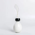 ABS tumbler cat toy with feather attachment in white colour, on a flat surface