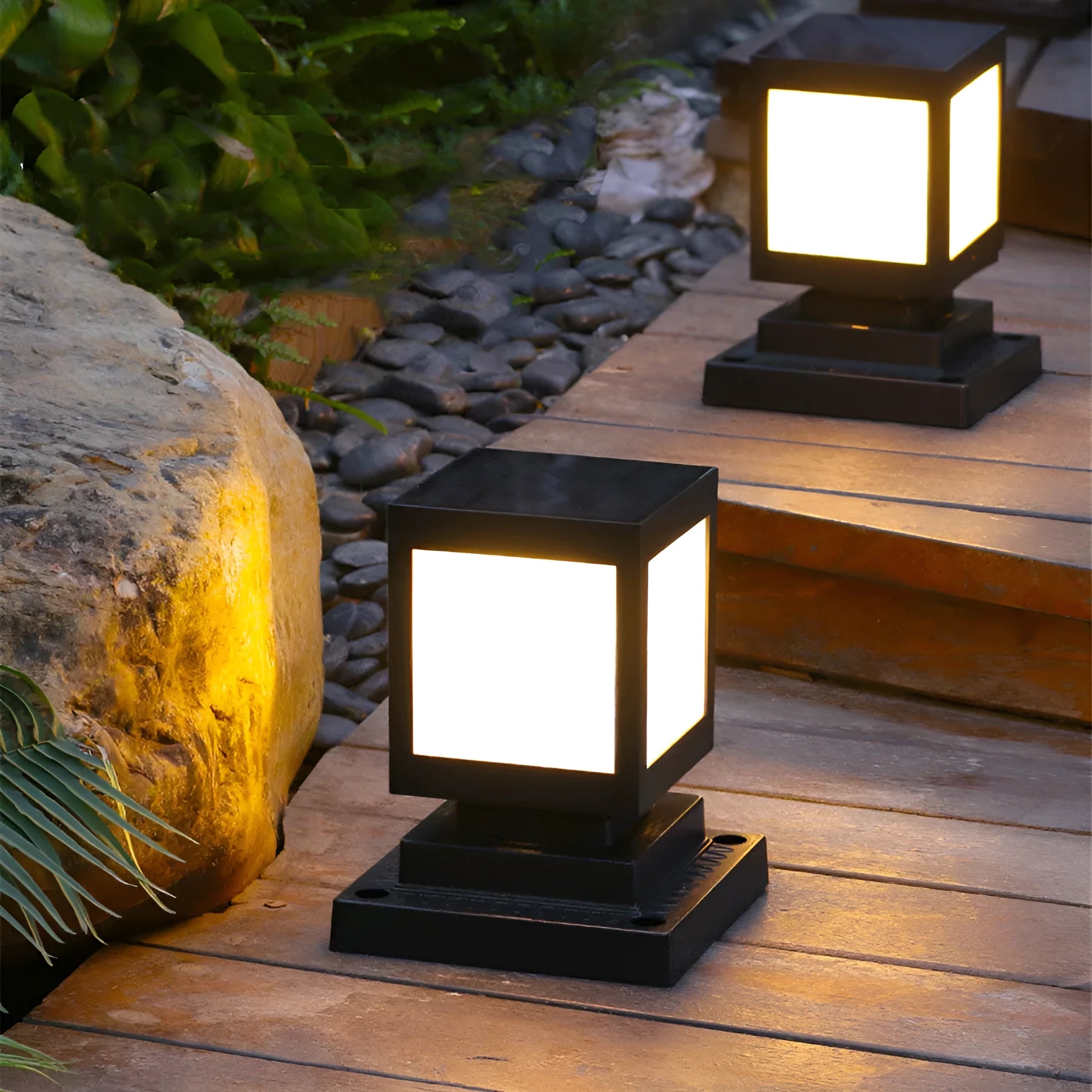 Set of four different styles of solar-powered LED garden lights for outdoor use.
