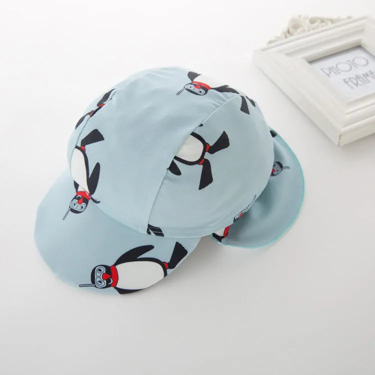 Boy's penguin print long sleeve swim shirt and matching cap set for sun protection.