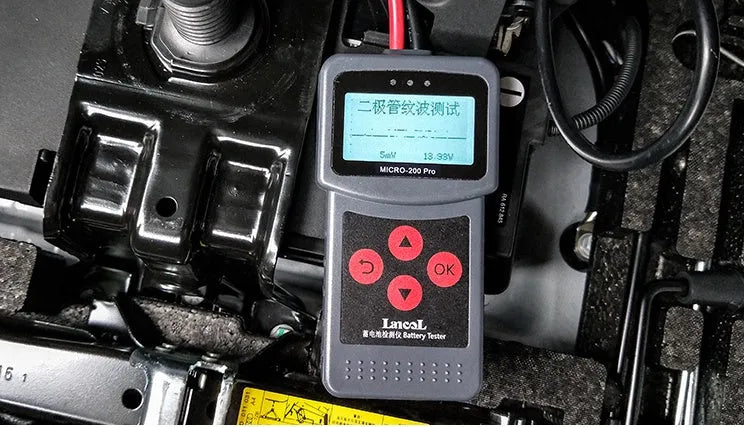 Black car battery tester with display and cables, measuring 15x6x3 cm